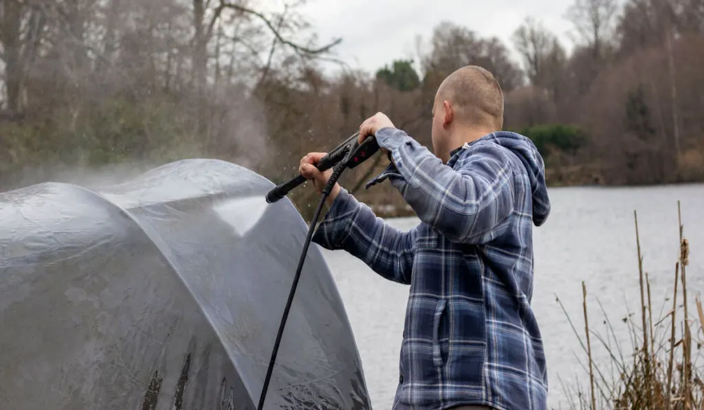 man washing out his tent 