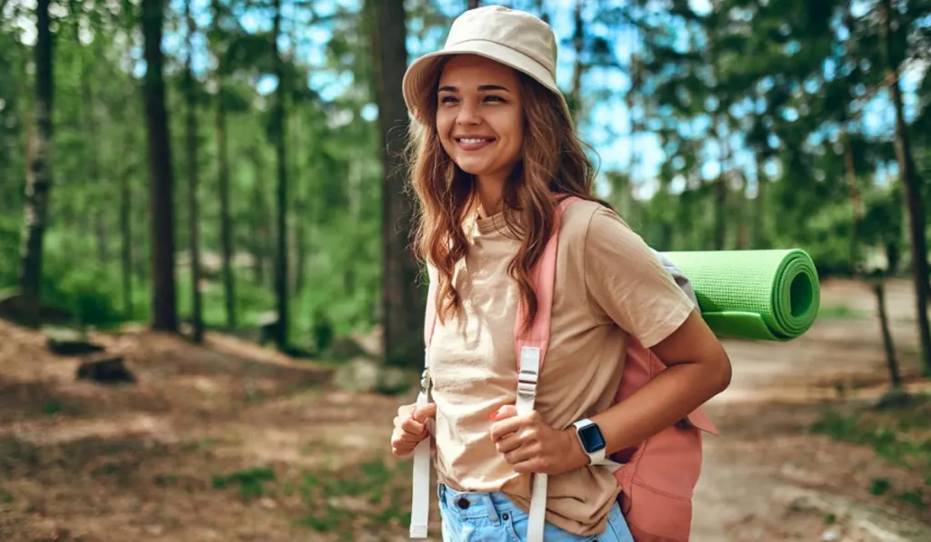 A woman hiker in a hat and a backpack