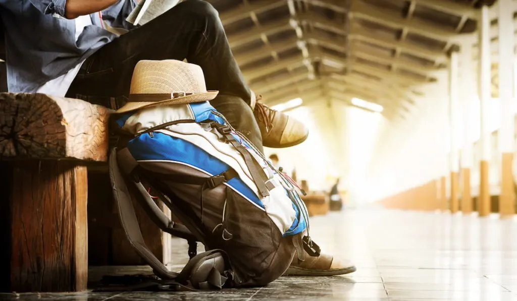 Backpack and hat at the train station with a traveler