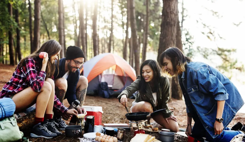 Breakfast Camping Cooking Concept, eggs and bread for group of friends