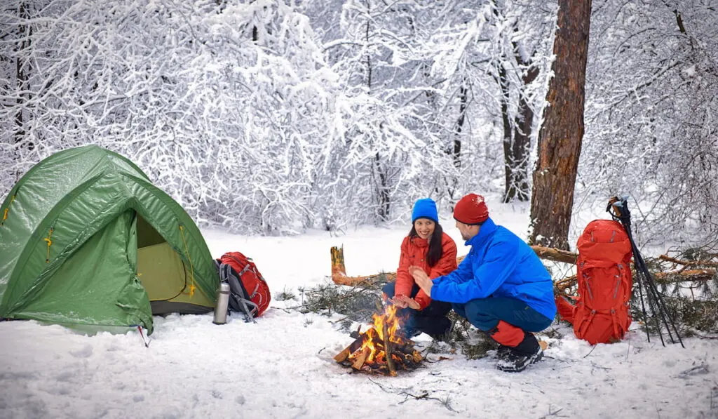 Camping in the winter forest of a couple