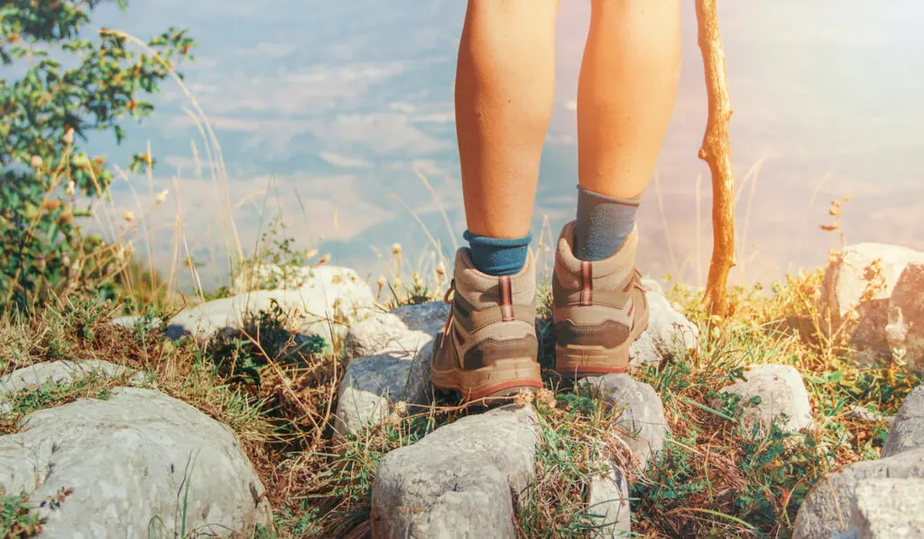 Close up of women legs wearing hiking boots in mountain
