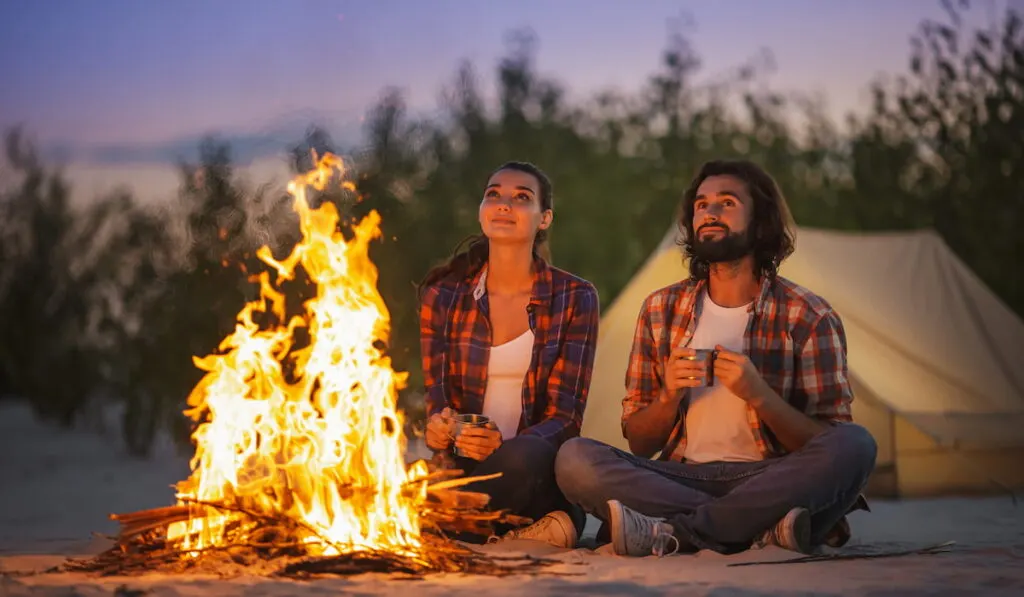 couple camping near campfire