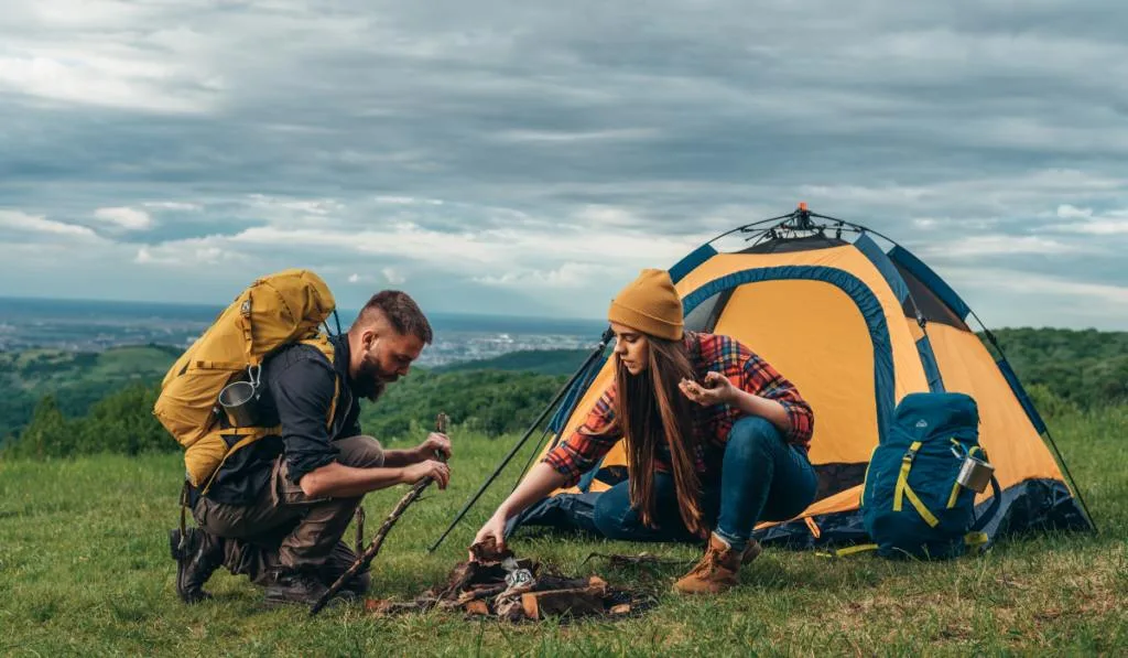 Couple of campers lighting a fire