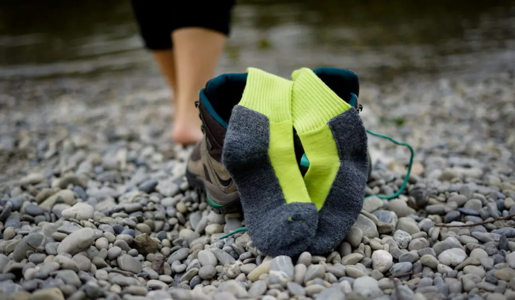 Detail of women's legs in hiking boots and yellow wool socks