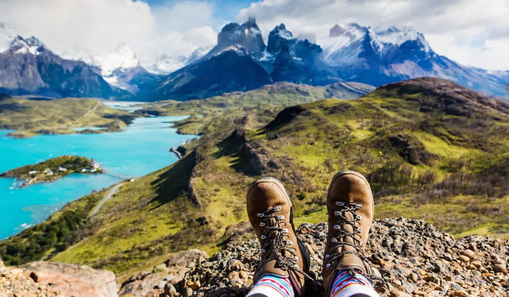 Girl hiking boots having fun and enjoying wonderful breathtaking mountain view