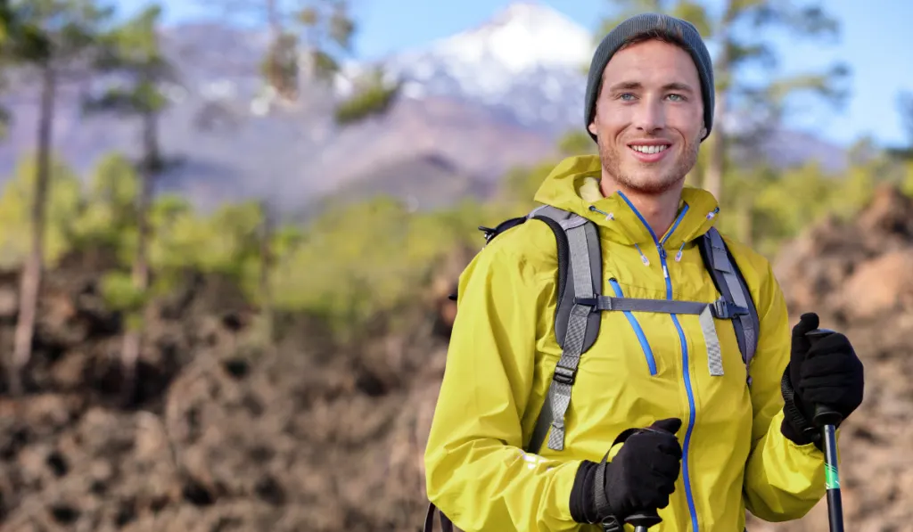 Hiker man hiking in forest mountain background