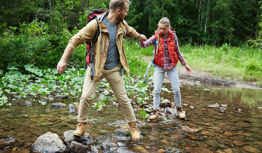 Hikers passing river
