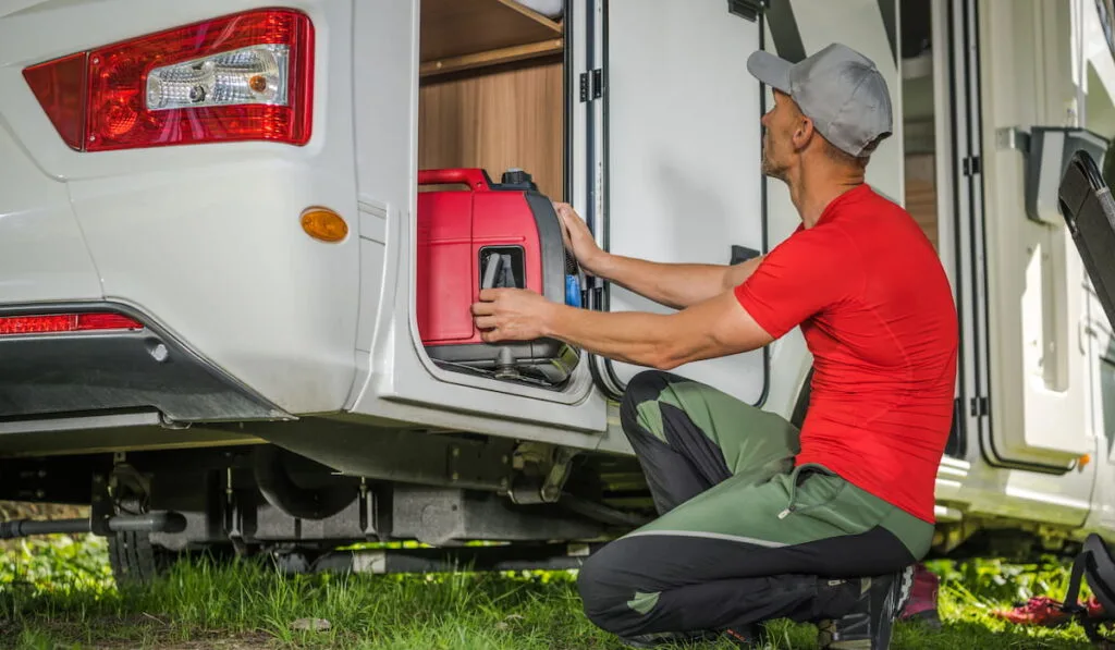 Man Removing Portable Gas Generator From His Camper Van RV Storage Area