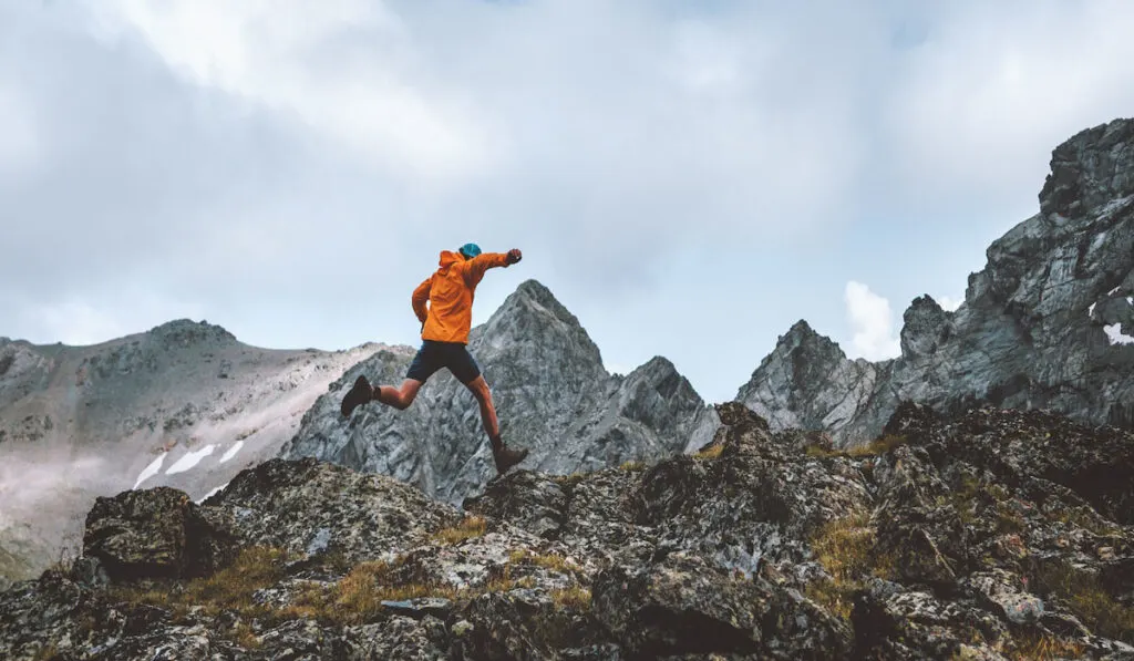 Man running in trail rocky mountains, travel hiking adventure activity outdoor