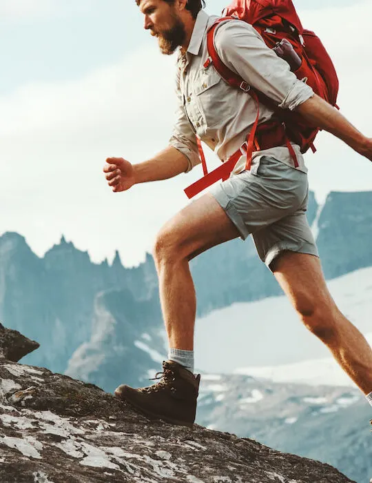 Man-skyrunning-in-mountains-with-backpack-and-wearing-hiking-boots-travel-hiking-concept
