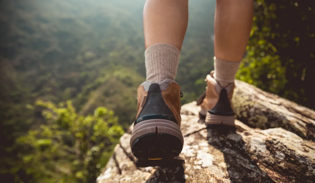 Successful hiker enjoy the view on mountain top cliff edge