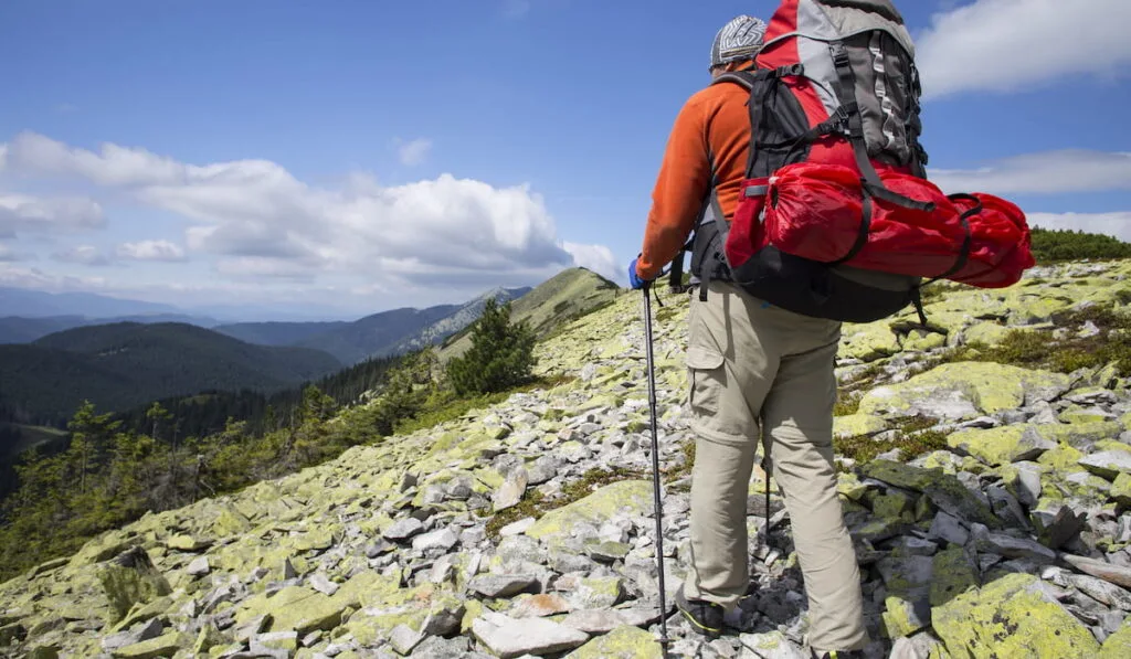 Summer hiking in the mountains with a backpack and tent.