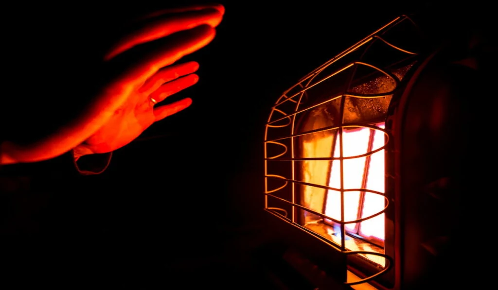 The warm glow reflecting off a heating element while warming up hands on a small space
