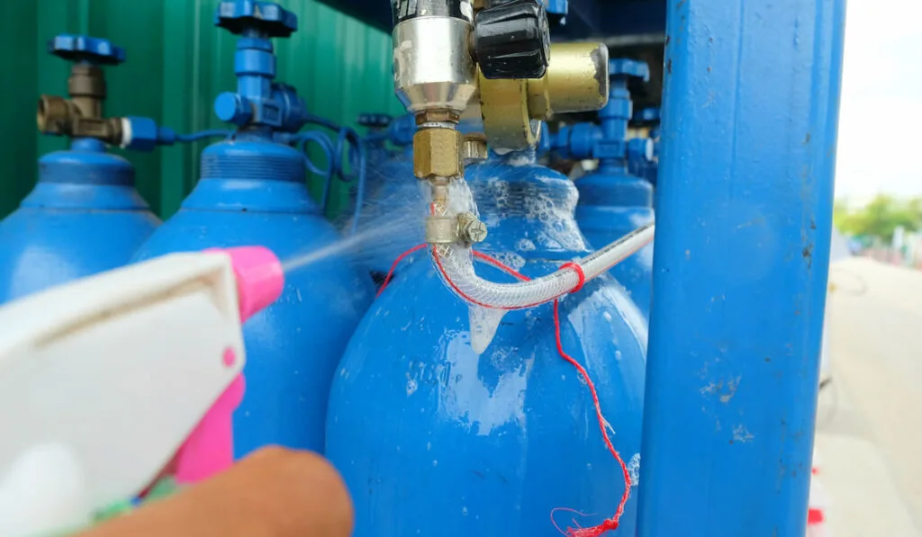 Workers use soap and water in the spray bottle to check tank leaks test.