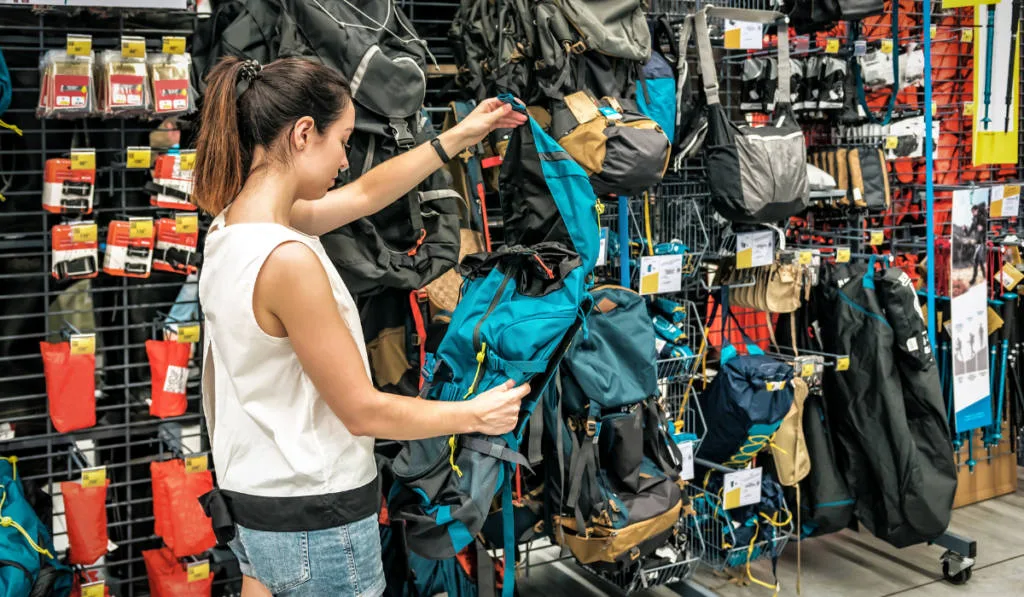 Young woman chooses a new backpack