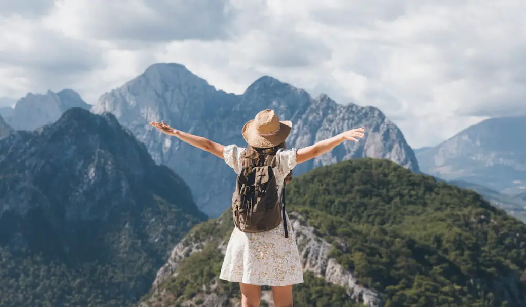 Young woman with a backpack hiking in the mountains