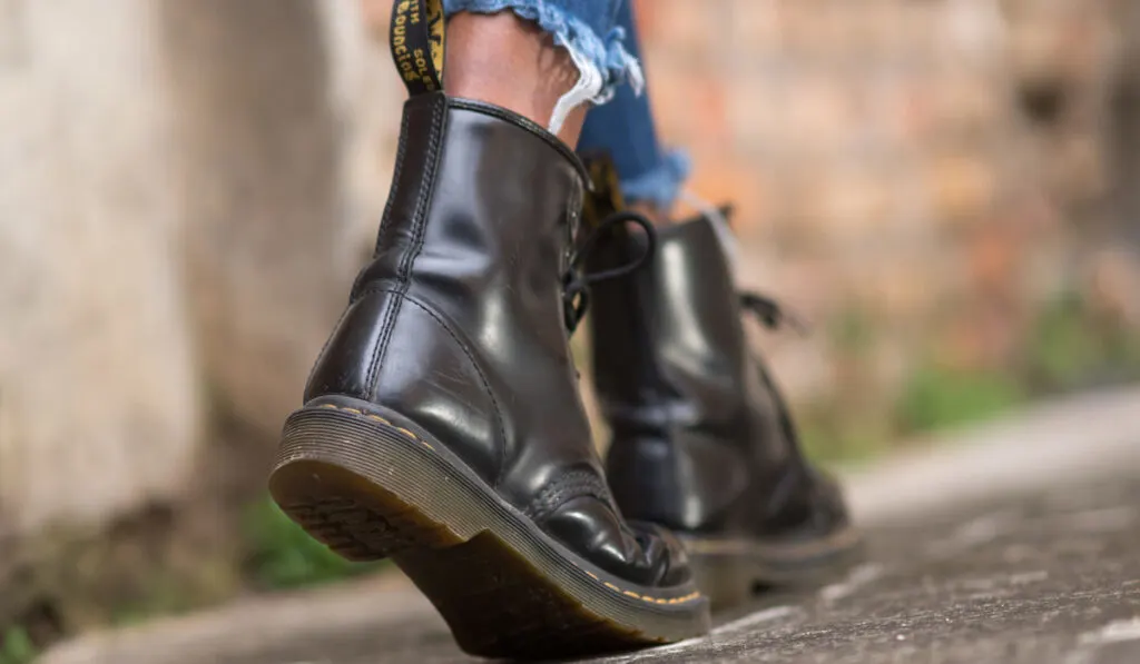 back view of a man walking wearing doc martens shoes 