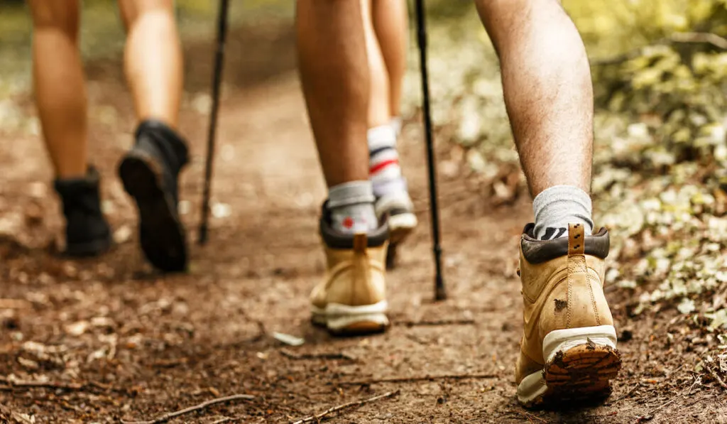 group of friends hiking only legs and tracking boots are visible 