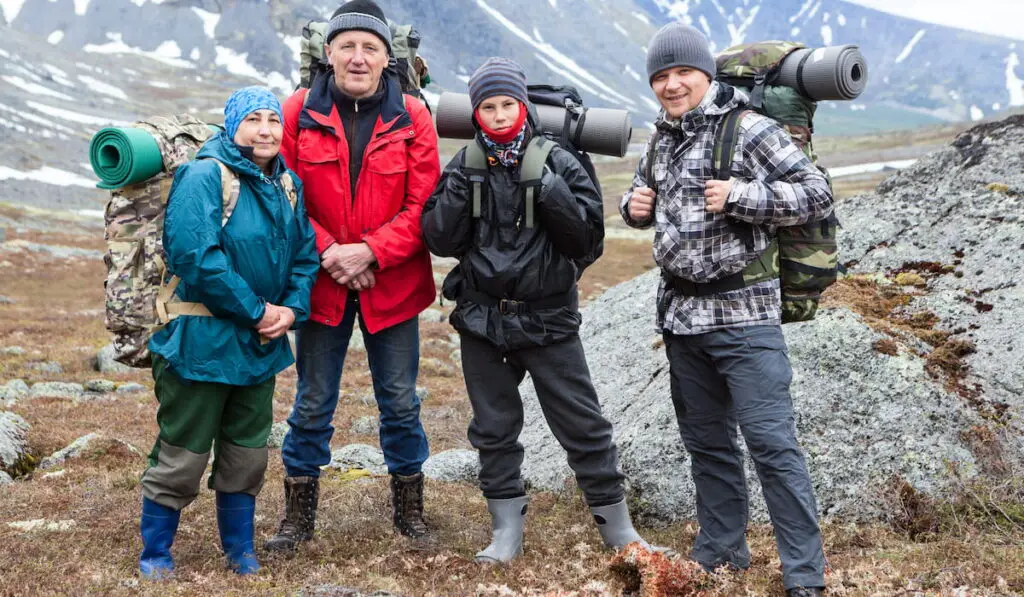 senior couple with young and adult men, happy mountaineers portrait