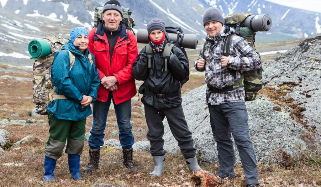 senior couple with young and adult men, happy mountaineers portrait