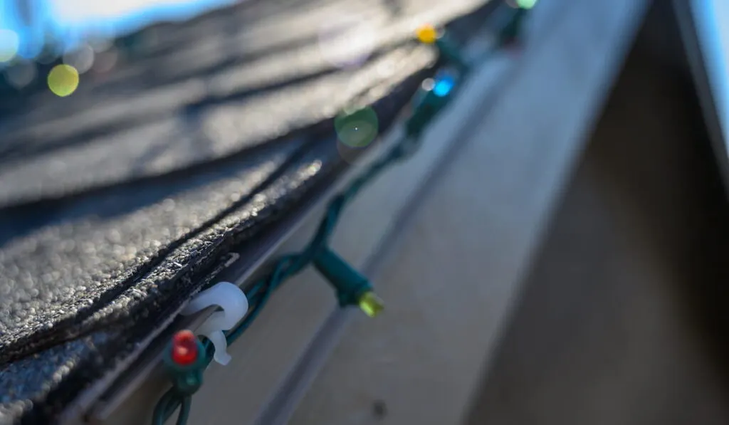 Hanging Christmas lights on roof edge with plastic clips