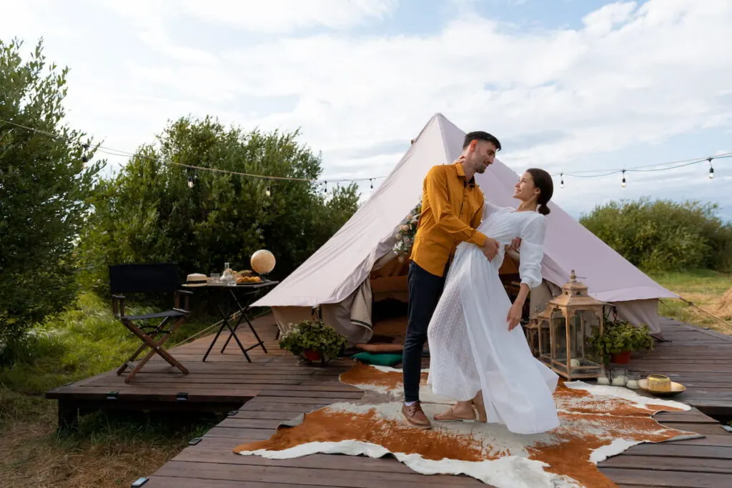 a couple dancing next to the glamping tent 