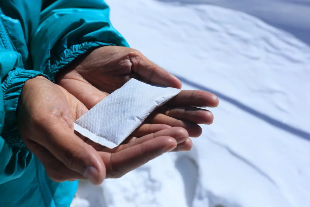 A person holding disposable heat pack 