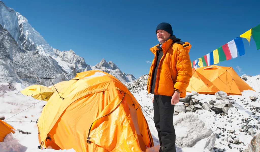 Man standing at base camp tent 