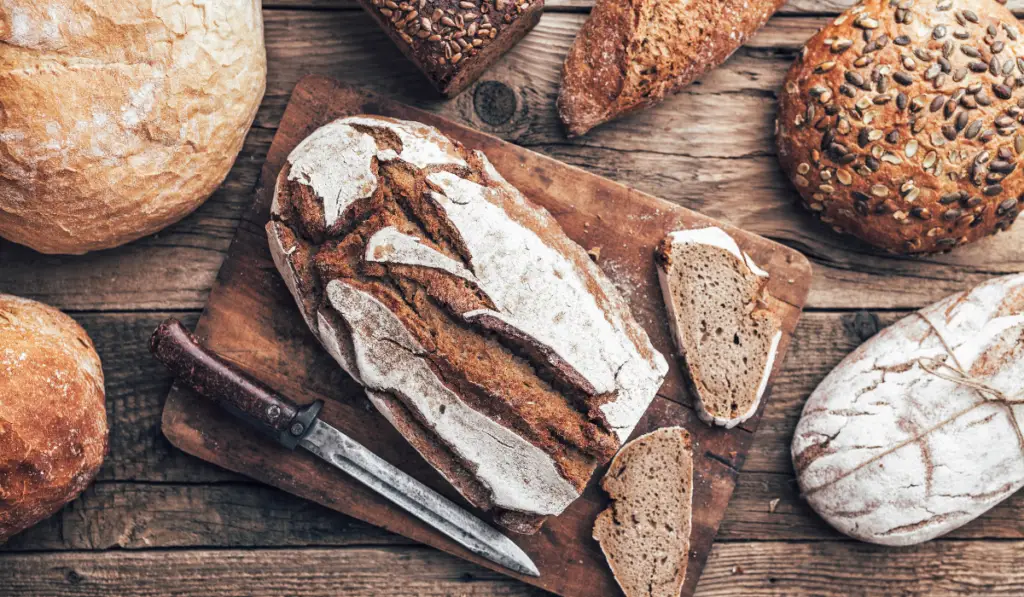 Delicious fresh bread on wooden background