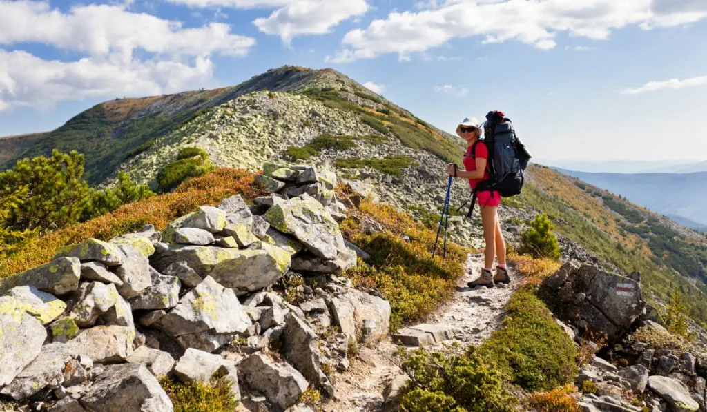 Slender girl in the mountains on the hiking trail
