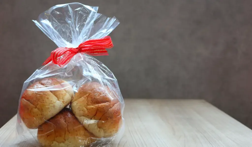 Bakery pack bind with red ribbon put on brown wooden table